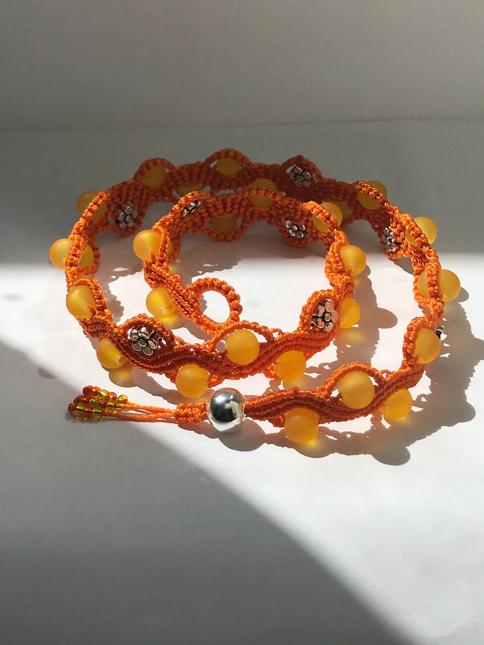 Thumbnail: Handmade macrame wrap bracelet in orange with Tibetan silver flower beads 