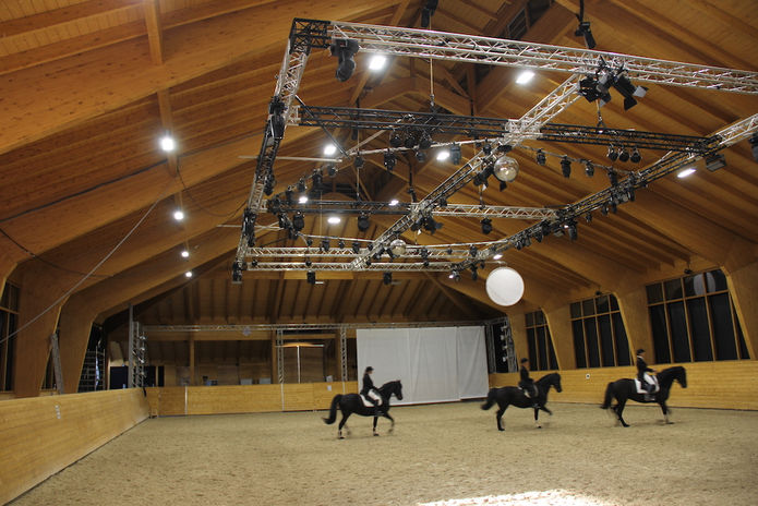 Große und moderne Reithalle mit Lichtanlage und Reitern
