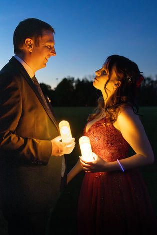 Wedding couple holding glowing lights at dusk