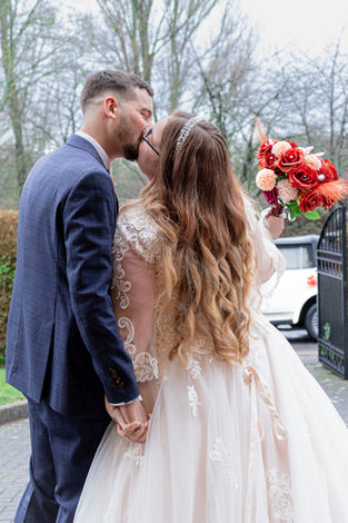 Wedding couple kissing outdoors, holding hands
