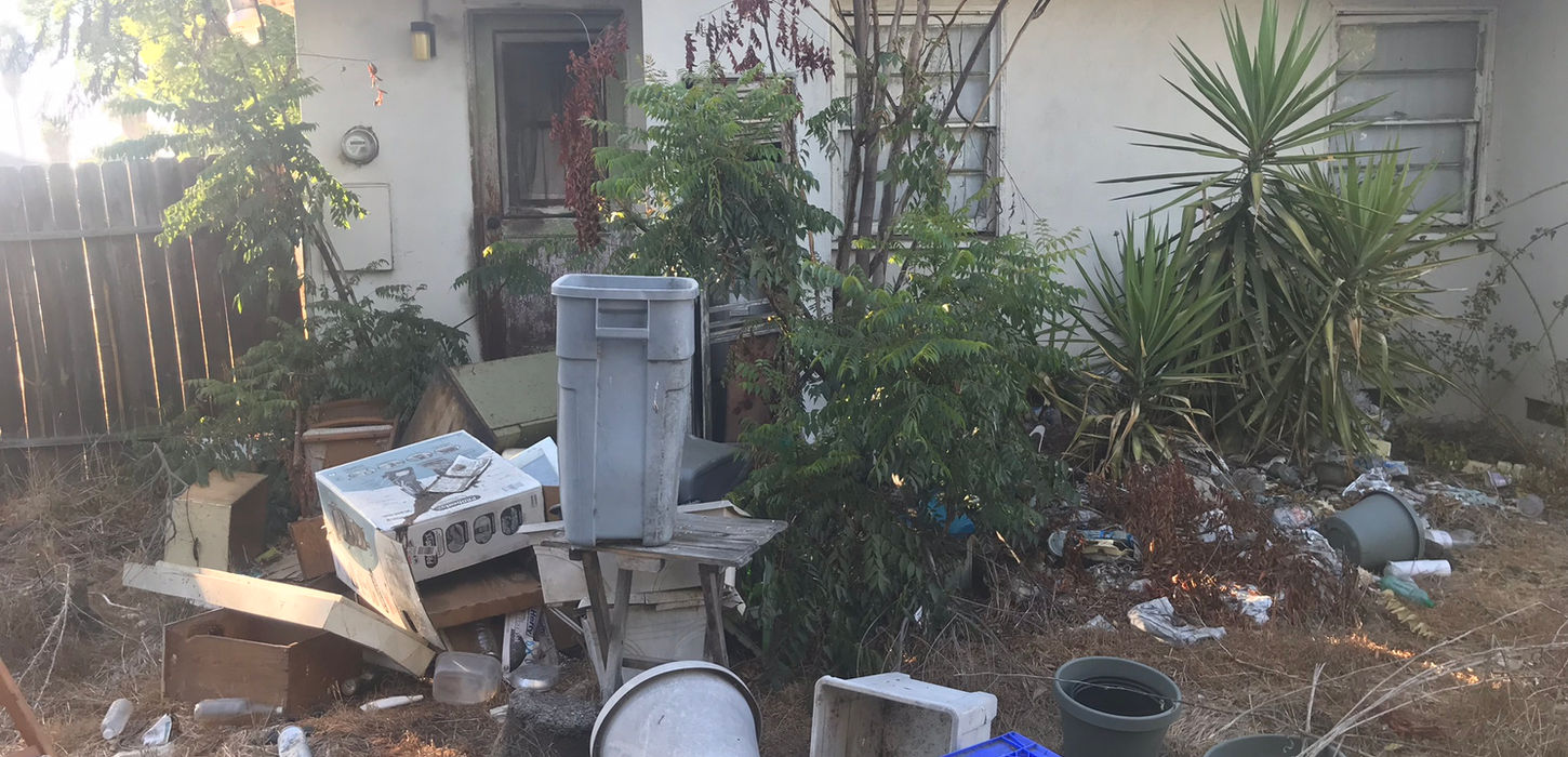 Neglected backyard with trash