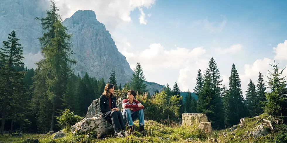 Carag sitzt mit Tikaani in der Naturkulisse von „Woodwalkers 2“.