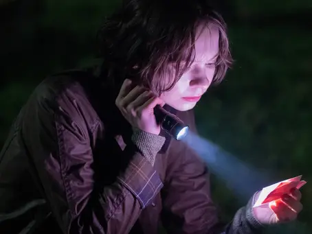 Emma Myers als Pip Fitz-Amobi in der Mystery-Serie „A Good Girl’s Guide to Murder“. Mit einer Taschenlampe untersucht die junge Detektivin nachts einen Hinweis und hält ein beleuchtetes Schriftstück in der Hand, während sie einem neuen Rätsel auf der Spur ist.