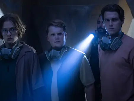 Szenenbild aus „Die drei ??? – Toteninsel“ (2026): Justus, Peter und Bob erkunden mit Atemschutzmasken und Taschenlampe einen dunklen Höhlengang im dritten Kinofilm der Jugendkrimi-Reihe.