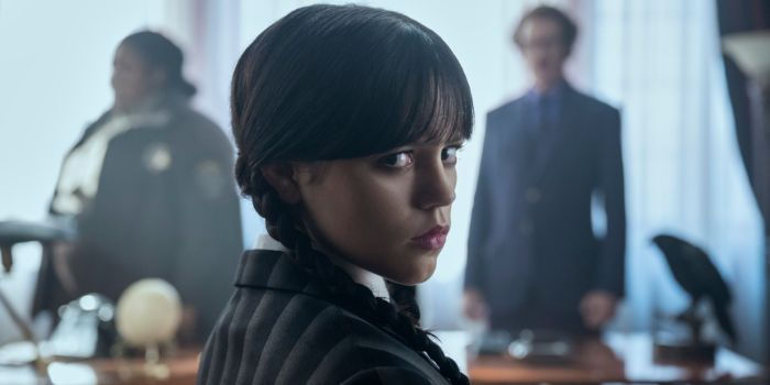 Jenna Ortega als Wednesday Addams in der Netflix-Serie „Wednesday“, im Hintergrund Figuren der Nevermore Academy; Serienbeispiel aus dem Netflix-Portfolio im Kontext der Netflix-Übernahme von Warner Bros.