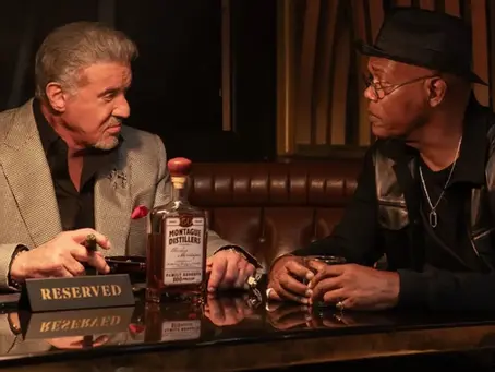 Sylvester Stallone und Samuel L. Jackson sitzen sich in einer Bar gegenüber, trinken Whiskey und sprechen miteinander – Szene aus „Tulsa King“.
