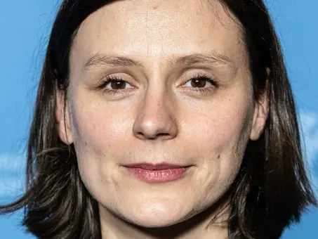Porträt der Regisseurin Sandra Wollner vor blauem Hintergrund.