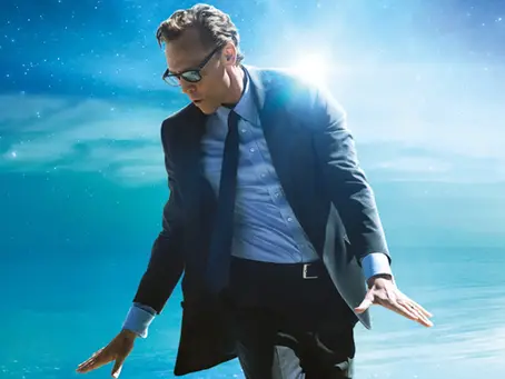 Kinoposter zu „The Life of Chuck“ mit Tom Hiddleston in Anzug und Krawatte, der vor einem blauen Himmel und funkelnden Sternen tanzt.