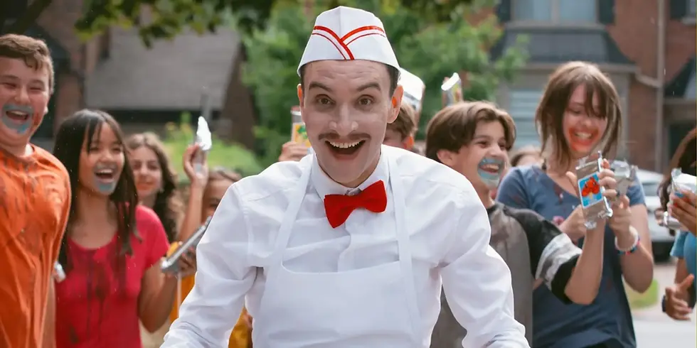 In „Ice Cream Man“ steht ein grinsender Eisverkäufer in weißer Uniform und roter Fliege vor einer Gruppe lachender Kinder.