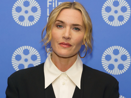 Porträtfoto einer blondhaarigen Schauspielerin (Kate Winslet) mit zurückgestecktem Haar, schwarzem Blazer und weißem Hemd, aufgenommen vor einem blauen Hintergrund mit wiederholtem „Film at Lincoln Center“-Logo.