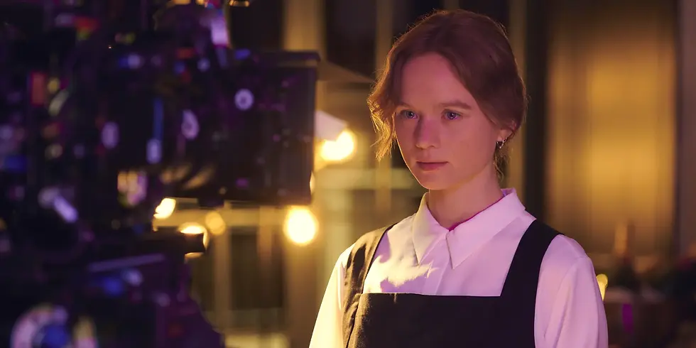 Sofie Eifertinger steht während eines Drehs am Set der Netflix-Serie „Kitz“ vor einer Filmkamera und blickt konzentriert in Richtung Objektiv.