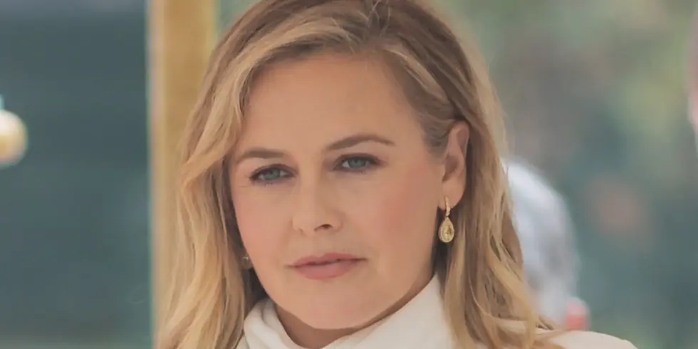 „Clueless“-Star Alicia Silverstone bei den 82. Internationalen Filmfestspielen von Venedig in Nahaufnahme, mit blondem Haar, weißem Outfit und goldfarbenen Ohrringen.