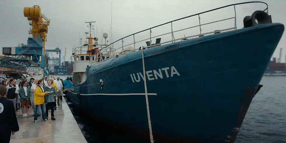 Das Rettungsschiff Iuventa liegt in Netflix’ „23.000 Leben“ an einem Hafen, während sich Menschen am Kai versammeln.