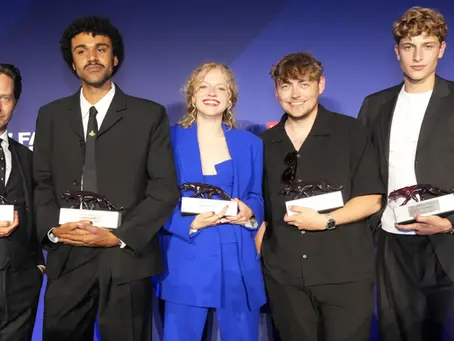 Die Gewinner des New Faces Award Film 2026 posieren gemeinsam mit ihren Auszeichnungen vor der blau beleuchteten Eventwand im Berliner Delphi Filmpalast. Zu sehen sind unter anderem Tom Schilling, Langston Uibel, Kya-Celina Barucki, Marc Philip Ginolas und Jonathan Kriener mit den Roten-Panther-Trophäen.