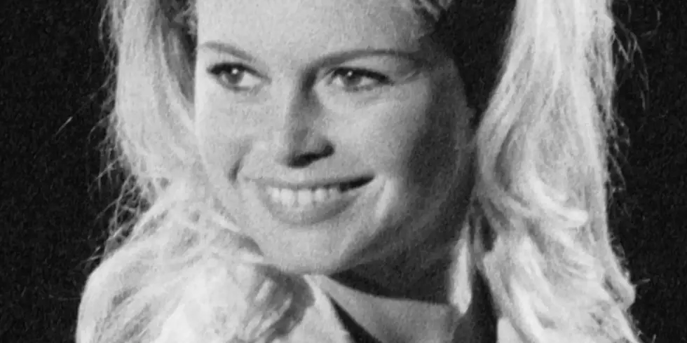 Schwarzweißfoto von Brigitte Bardot aus dem Jahr 1961: Eine junge, blondhaarige Frau lächelt in die Kamera.