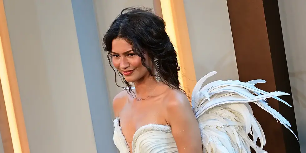 Zendaya bei der New Yorker Premiere von „Die Odyssey“ am 14. Juli 2026. Sie trägt ein weißes, federverziertes Kleid und posiert vor der Premierenkulisse.