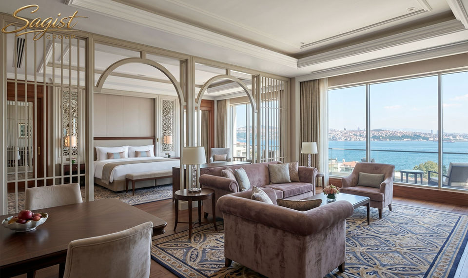 Hotel guest room casegoods by Sagist Group — wardrobe, minibar unit, writing desk and TV console in matched walnut veneer programme, produced on CNC and pressure-veneer lines in Istanbul.