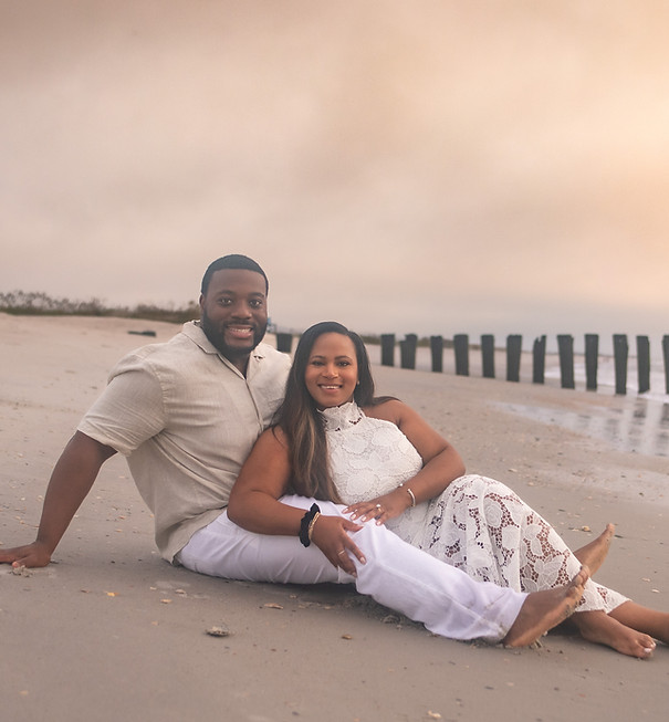 Couple sitting together on the beach at sunset — Eastern NC engagement photography by Hawk Feather.