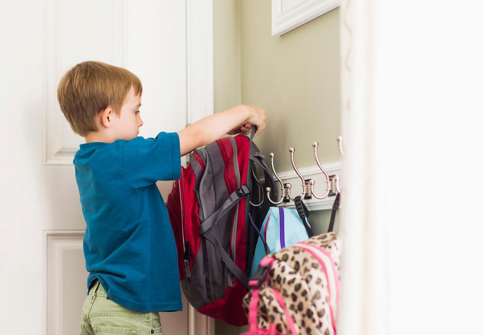 Child hanging up a coat at the front door