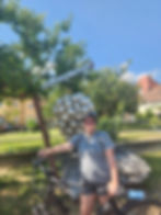 Travel Agent Lindsey Markwood on her ebike resting. In the background is a statue of grape leaves.