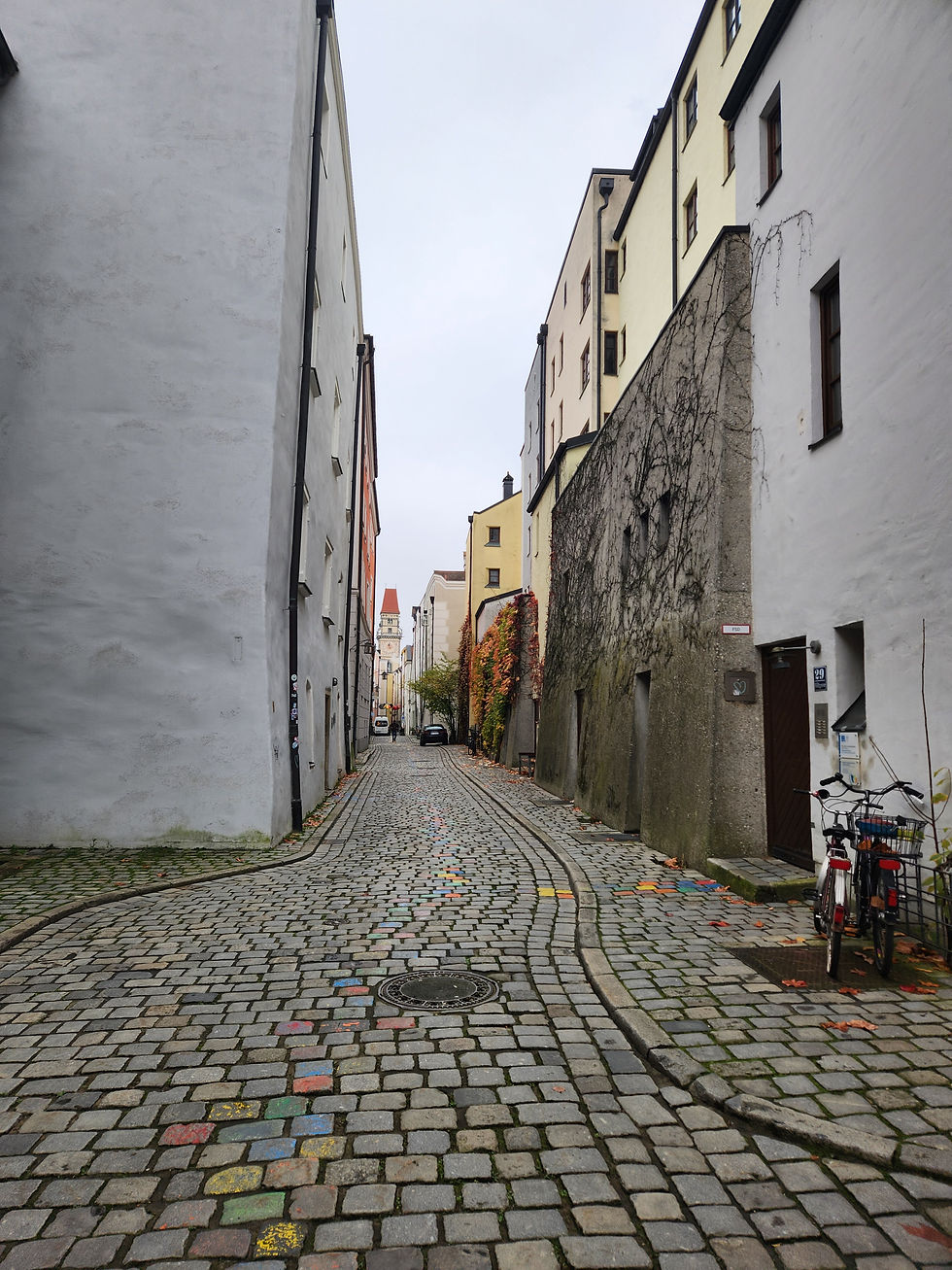 A travel advisor's point of view perspective of the uneven colorful cobblestone streets in the historic center of Passau Germany illustrating the need for supportive walking shoes for a Danube River cruise