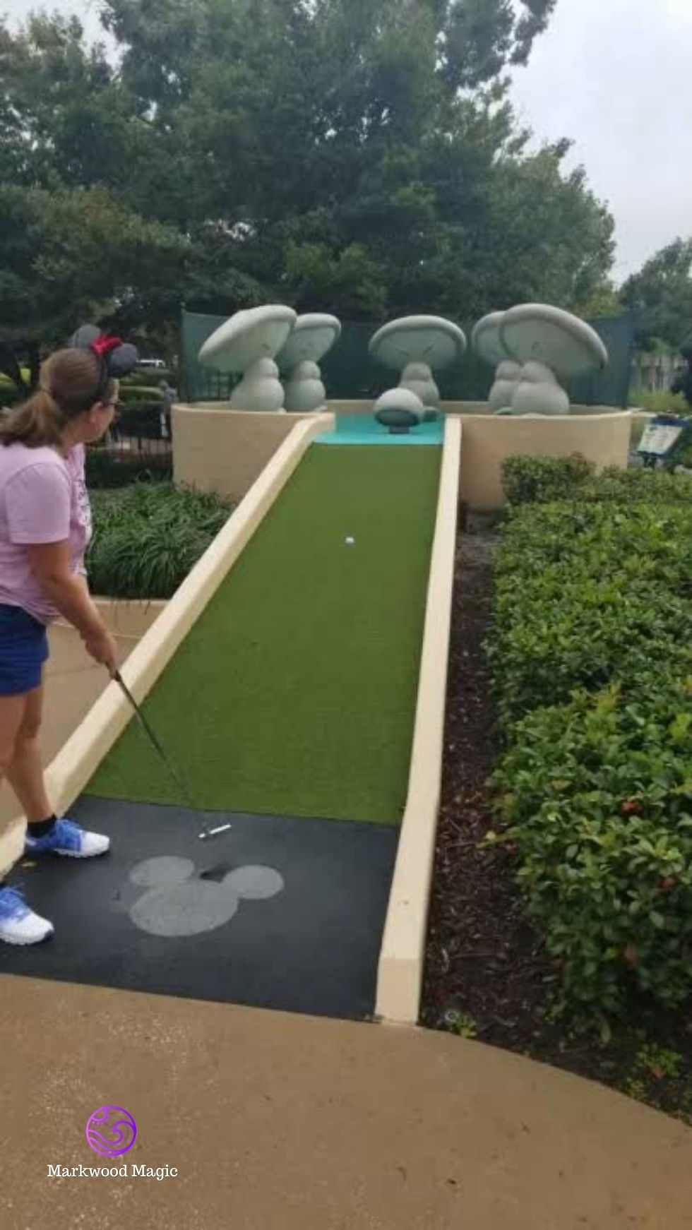 travel agent Lindsey getting ready to score a hole in one. the ball is almost all the way up the ramp. At the top of the course Hop Low and the Dancing Mushrooms..