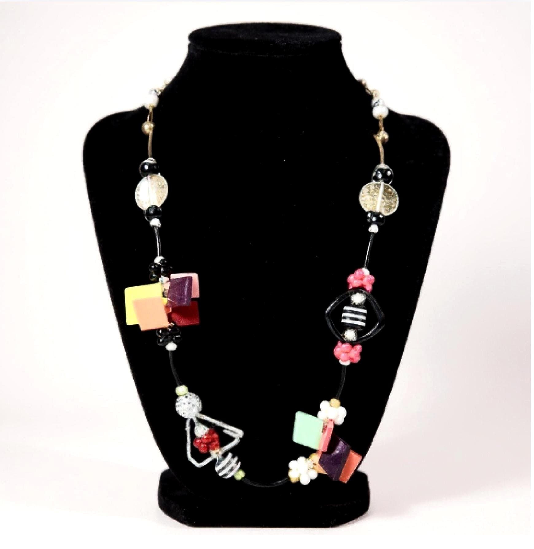 Colorful beaded necklace on black stand. Hand-Painted Gold and White Beaded Necklace, formal jewelry.