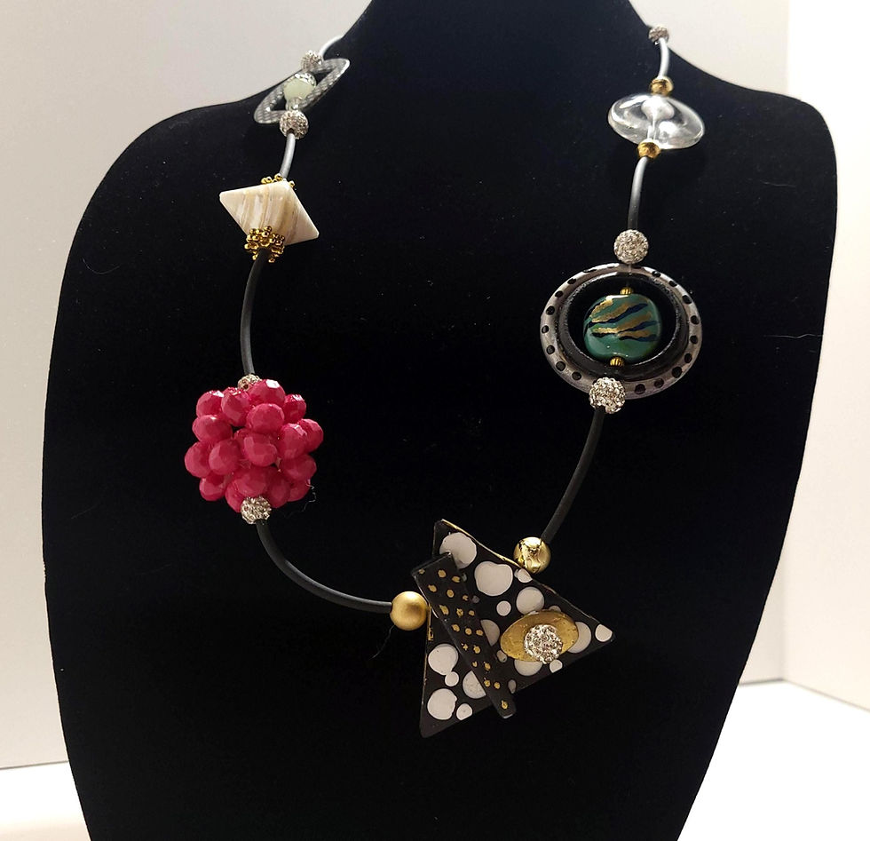 Abstract necklace on display featuring red, black, and white accents on a black background.