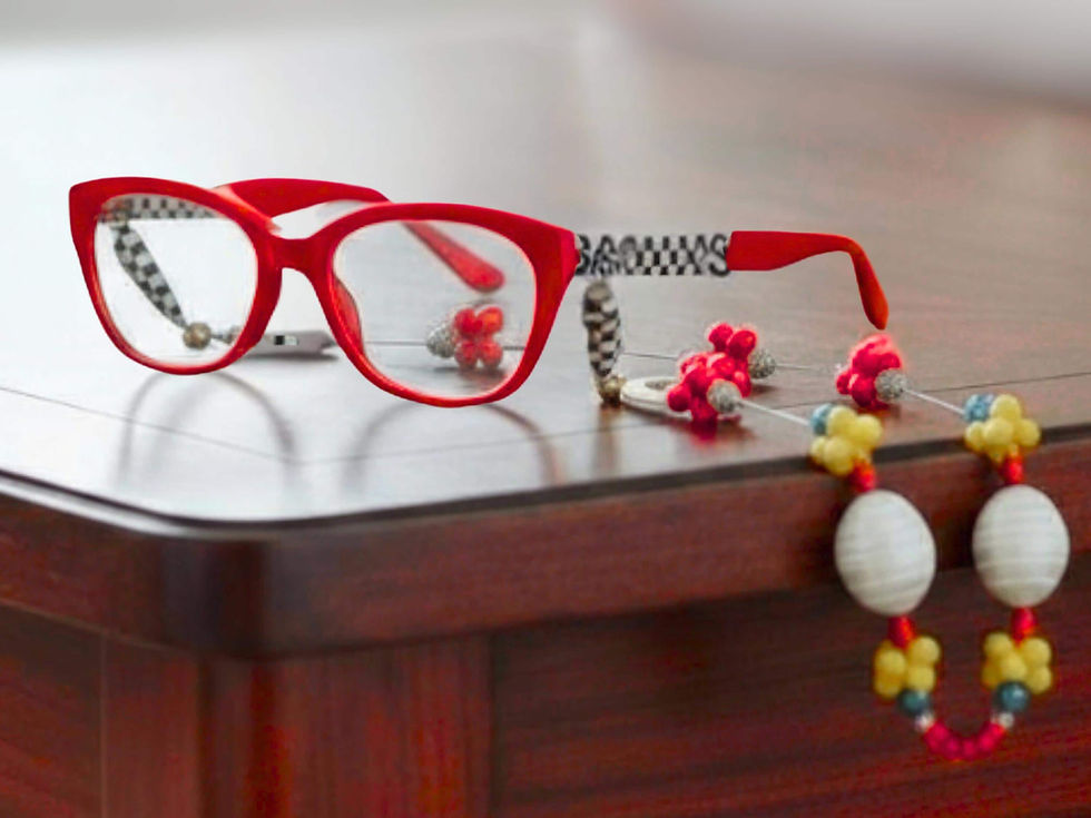 Thumbnail: Red eyeglasses with accessories on a wooden table. Mahjong Beaded Eyeglass Chain.