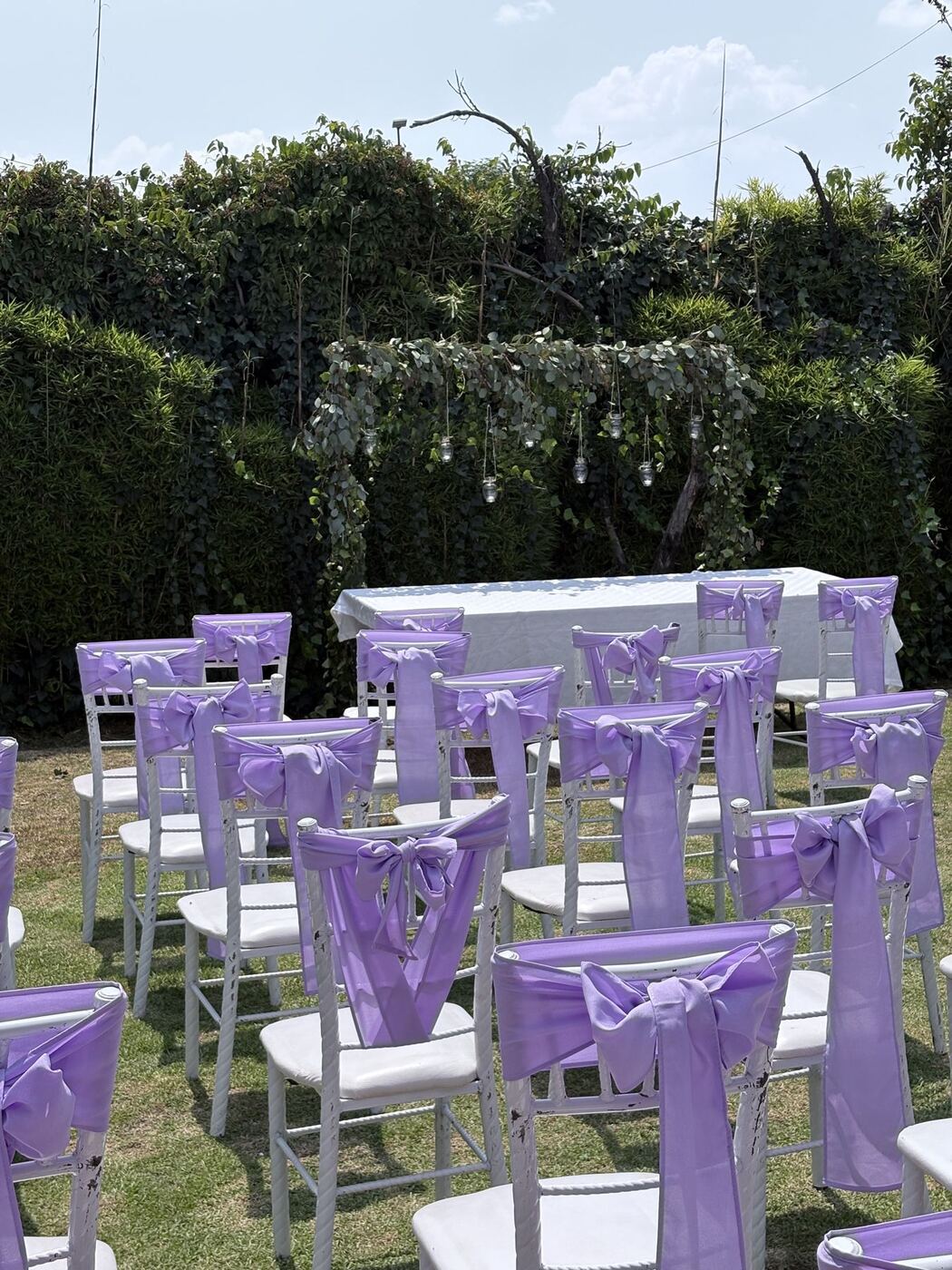 Ceremonia en el jardín con sillas decoradas en lila