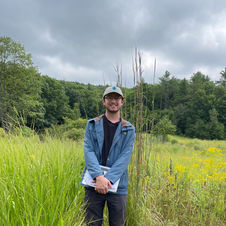 Mike posing for a picture in a field