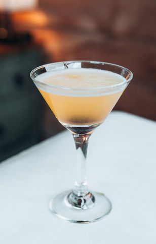 Elegant cocktail in a martini glass on a white table background