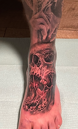 Macbre skull custom foot tattoo designed and tattooed by Ocala Florida tattoo artist Gregg at The Tattoo Gallery of Ocala, LLC