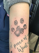 Black and grey paw print tattoo designed and tattooed by Gregg