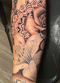 Black and grey realism tattoo. Lily, rose, and mandala custom tattoo designed and tattooed by ocala florida tattoo artist Gregg at The tattoo Gallery of Ocala, LLC