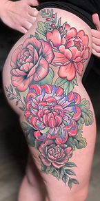 Roses, peonies, and greenery in this custom designed floral hip piece tattoo designed and tattooed by Gregg at The Tattoo Gallery of Ocala, LLC