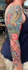 Custom vibrant tropistyle flowers and waves half sleeve tattoo created by Ocala Florida tattoo artist Greg at The Tattoo Gallery of Ocala