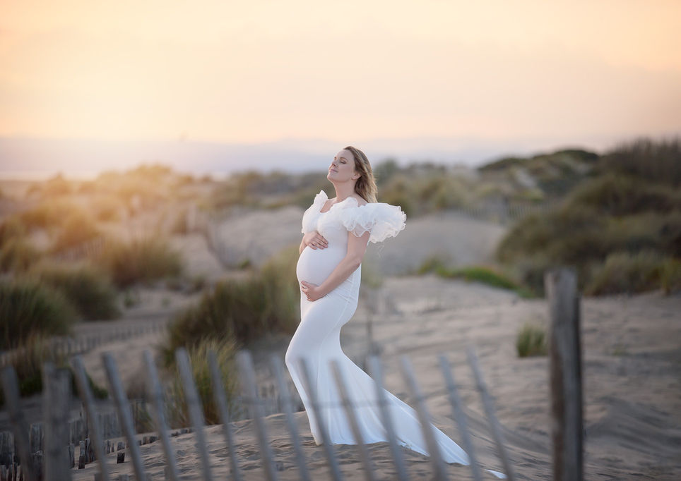 Femme enceinte dans une robe blanche dans les dunes de l'Espiguette - Photographe  grossesse et maternité en extérieur entre Montpellier et Nîmes - Ohana Photographie by Virginie Peigne - Séance photo future maman et maternité
