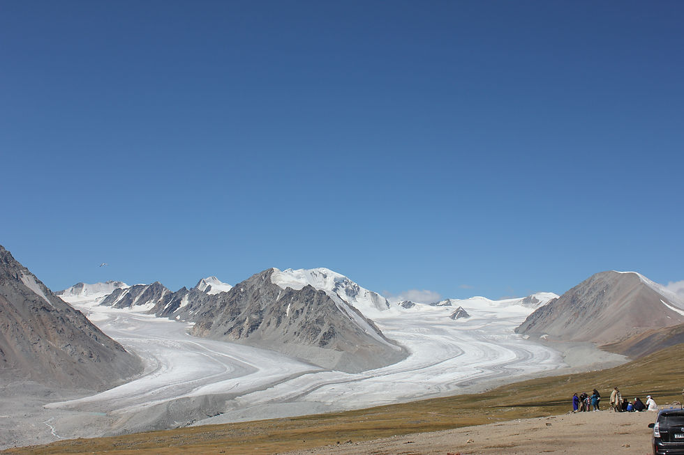 アルタイ山脈の氷河地帯を訪れる人々と、雪峰が連なる大自然の景色