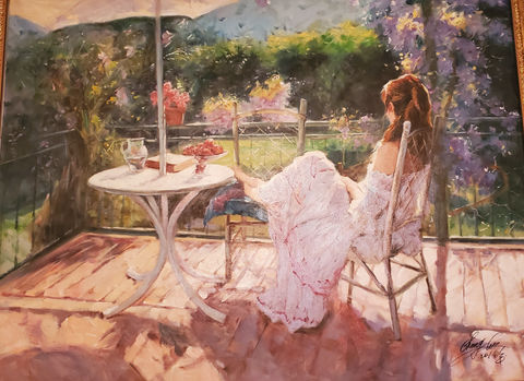 Woman in white dress relaxing on veranda overlooking garden