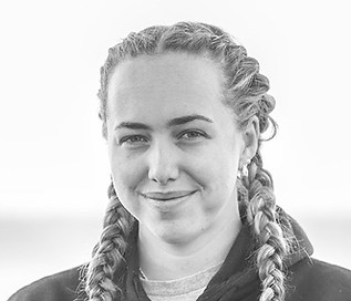 Portrait of SCAR Development & Assistant Coach Alexandra Morris smiling with braided hair and wearing a team jacket.