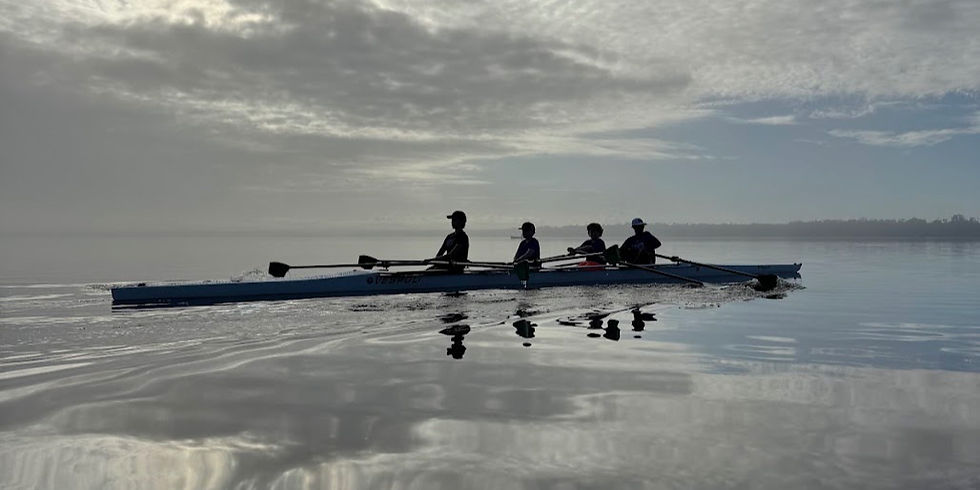 SCAR rowers practice on Lake Jesup at sunrise, rowing a four-person shell across calm water with dramatic cloud reflections in Seminole County, Florida.
