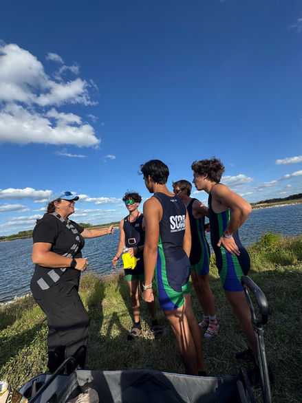 Coach talks with SCAR athletes during a regatta or outdoor event.