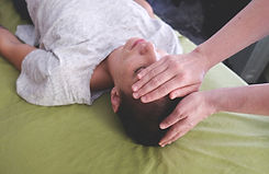 Marshall's hands on a client's head during a Reiki treatment