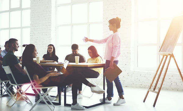 Male and female creative students listening explanation of female train manager during wor