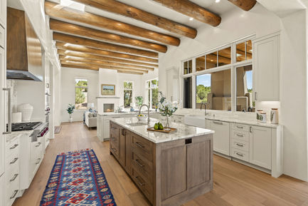 Santa Fe transitional kitchen with marble-top island and living room view.  Design by Salomon Velasquez.