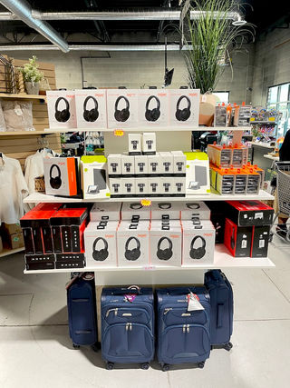 A retail display with consumer electronics and carryon luggage