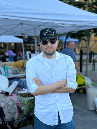 Joseph standing in front of a booth at a community event