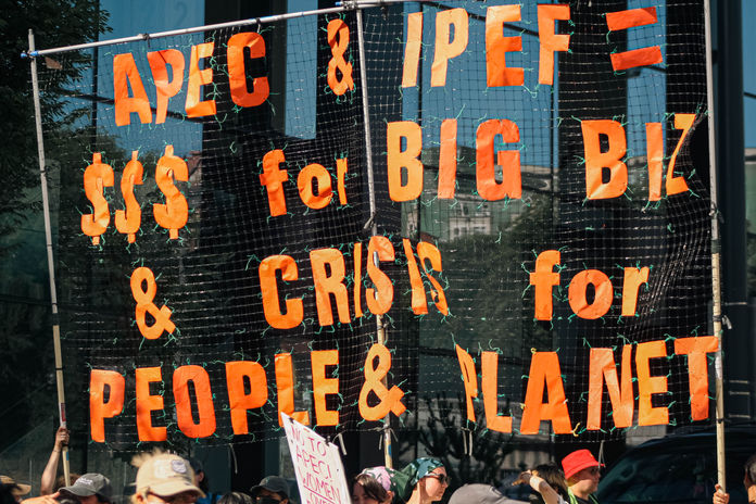 A large banner reads, "APEC & IPEF = $$$ for Big Biz & Crisis for People & Planet."