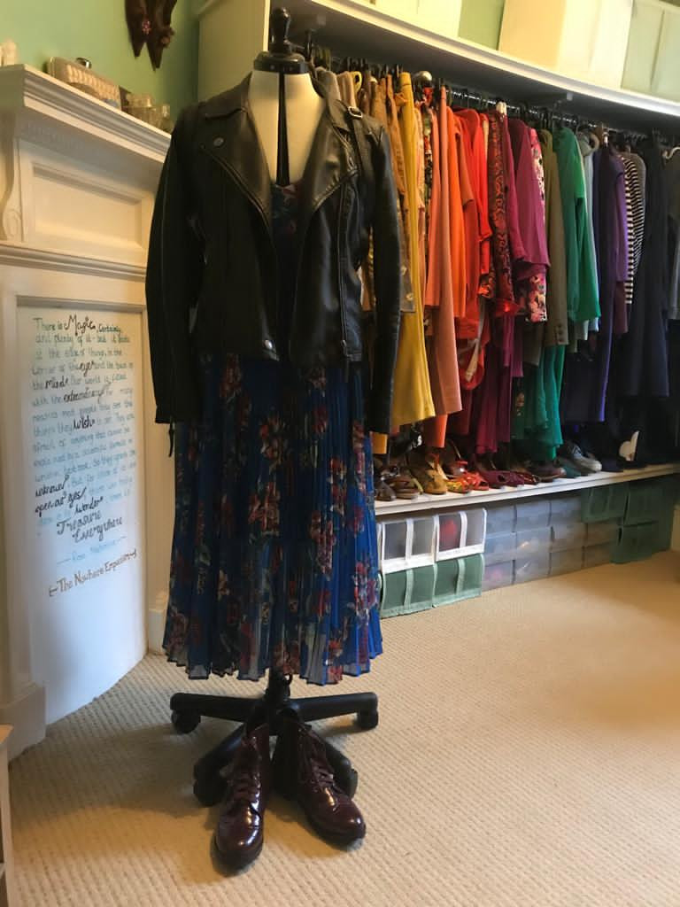 Floral dress on a mannequin with flat red boots and a leather jacket